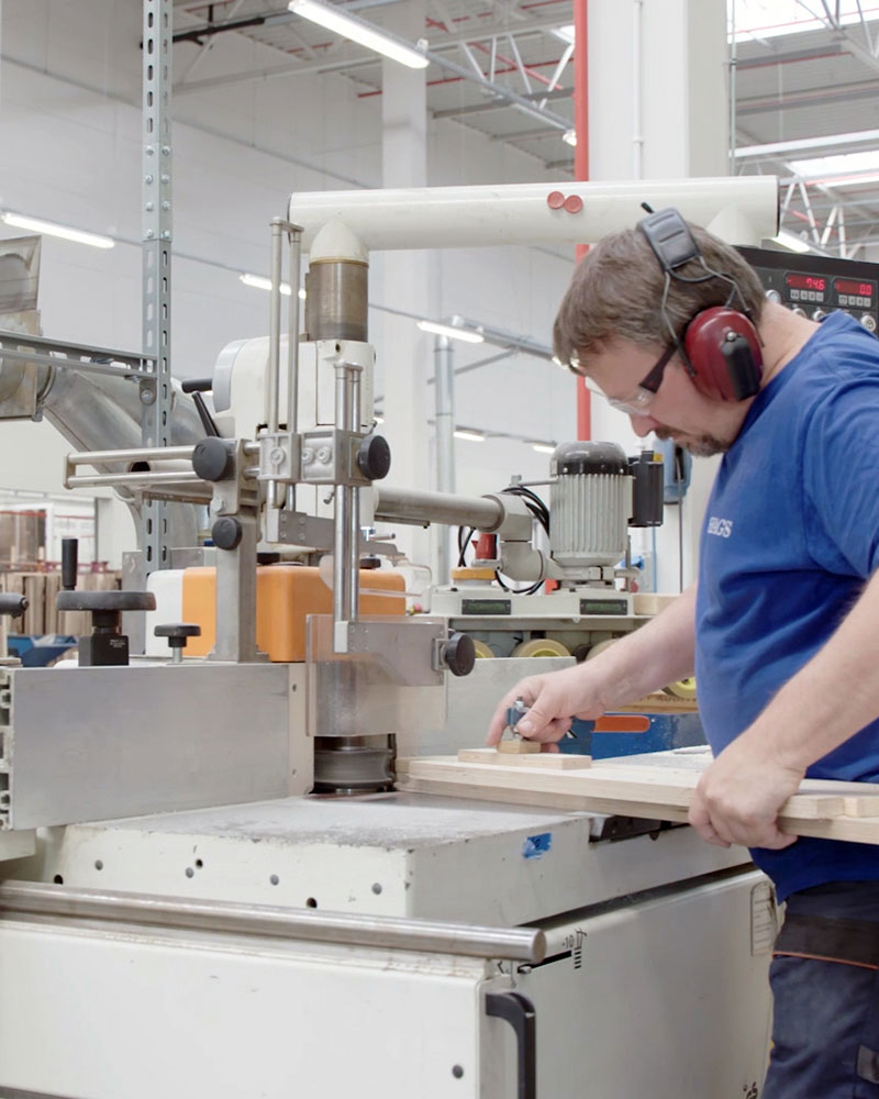 A HAGS employee working at a warehouse factory on wooden components.